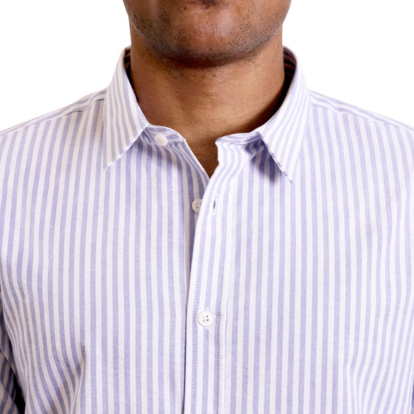 close up view of the pointed collar and neck area of soft blue and white cotton fabric button up shirt showing the vertical business pattern of the shirt. Worn by a black male model. The top buttons are undone