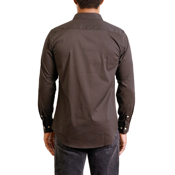 back view of a men's long sleeve, button up woven cotton dress shirt in a tan and white small print on black shirt. Worn by a black male model